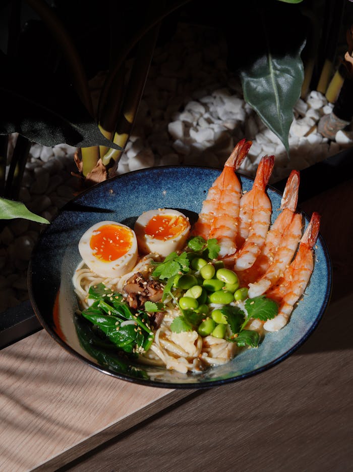 Delicious shrimp ramen bowl with soft-boiled eggs, edamame, and greens.